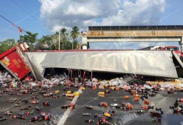 Accidente entre tráiler y autobús, deja decenas de refrescos sobre la carretera