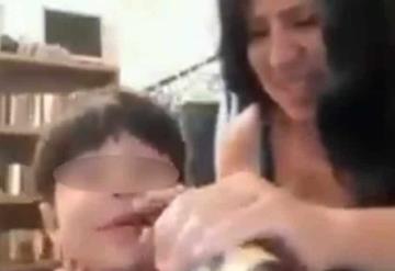 Mujer  fuma y bebe cerveza con su pequeño hijo