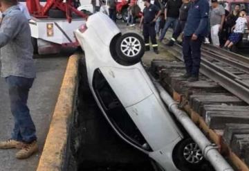 Auto cae a canal de aguas negras