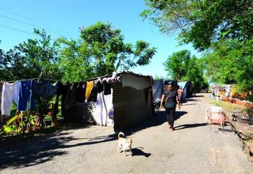 Viven en la orilla de la carretera, sus casas siguen inundadas