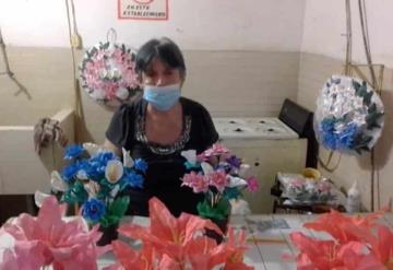 Adulta mayor elabora tradicionales coronas de papel para honrar a los muertos