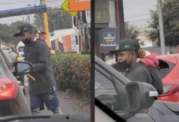 Captan en video a joven cargando a su perrito en la espalda al trabajar limpiando parabrisas