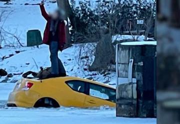 Se toma selfis parada sobre su coche mientras se hunde